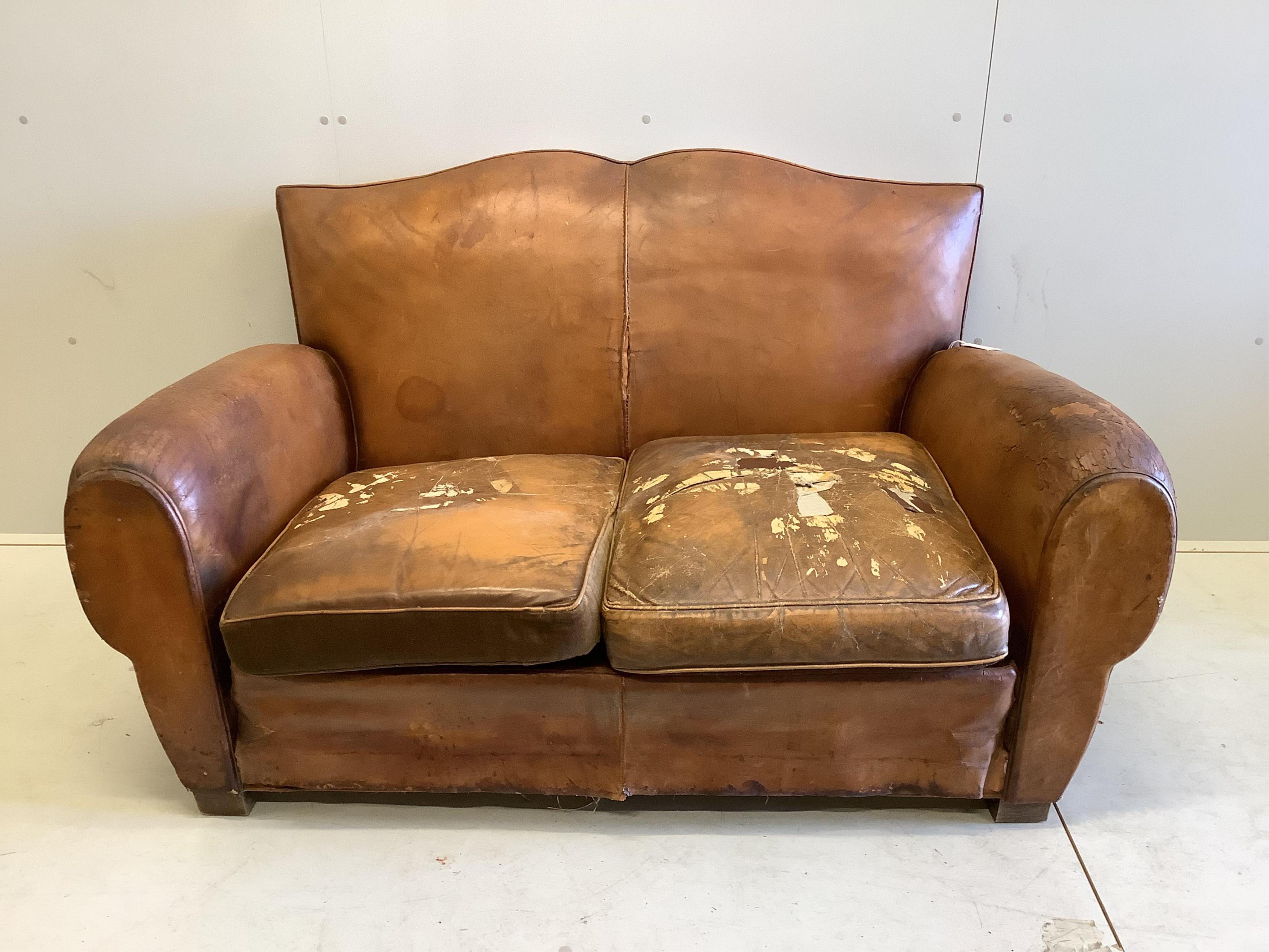 A French leather moustache back sofa, width 148cm, depth 80cm, height 80cm. Condition - poor